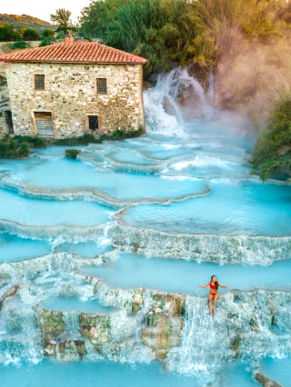 TUSCANY - BEST ITALY HOT SPRINGS

One of Italy´s highlights and a MUST SEE are the Natural thermal baths in Tuscany.

Imagine silky blue water heated by the nearby volcano with a temperature of 37,5 degrees. Add a breathtaking landscape typical for the Tuscany area and you get "Cascate del Mulino".

Hot springs in Saturnia - a spa town in Italy. A natural waterfall coming out of the earth and flowing down all levels filling the natural cascade pools. The Saturnia hot springs in Tuscany are completely for free. There is no entrance fee neither parking fee.

Tuscany hot springs are 80 km from Rome, 200 km from Florence and 75 km from Orvieto.

Saturnia´s thermal baths are said to be the most beautiful hot springs in Italy. And we can´t agree more! But don´t let people fool you by calling them Italy´s best-kept secret! These hot springs are well-known and they are very popular.

To enjoy this place peacefully and privately, you need to come before 6 am. It´s not hard to understand why so many people come every day to visit Tuscany´s hot springs.
Bubbling waters rich in mineral deposits coming out through the Earth´s crust near volcano Mount Amiata. The Cascate del Mulino is made of several natural pools of warm thermal water. They are open to the public and free FREE to visit 24 hours a day, 7 days a week, 365 days a year.
Sulfur contained in the hot springs gives it sometimes quite strong "eggy" smell. Romans believed these waters are a gift of God and have a therapeutic effect.

Contains: sulphurous-carbonic, sulphate-bicarbonate-alkaline mineral water, and includes among its peculiarities the presence of two dissolved gases such as hydrogen sulphide and carbon dioxide.
The sulphur contained in the water can stain your jewellery. Especially silver will more likely turn black. But there is no need to be worry! You can easily fix it by rubbing toothpaste onto your jewellery.
#awesomepic #couplestrip  #unforgettableexperiences #scenicspotguide  #travelinspiration #italy
#awesomepic