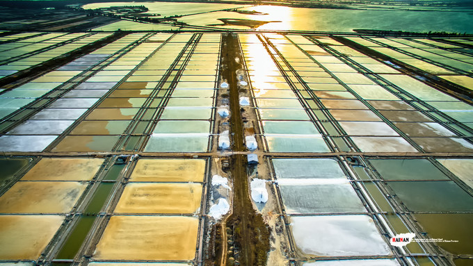 A huge piece of salt marshes, arranged in turn in the distance, stretches for several kilometers, like a vast expanse of farmland. Under the illumination of the sun, it shows different colors and draws a magical picture. 

 Between this seemingly white, the workers who work in it are particularly obvious, but they are exceptionally small. Despite the fact that today's Yinggehai Salt Field is gradually shrinking, it is still very shocking. 

Twilight is approaching, the sun-like sun gradually recedes into the temperature, turning into a golden ball, shining on the salt marsh. The salt water passes through the reflections, and it also displays a variety of fascinating colors, spreading in the heavens and the earth. 

Yantian filled with salt water, because of the different time of the sun, it shows different colors. This huge square is like a natural palette, with endless colors, bringing countless shocking visual impacts. 

 Overlooking the heights, these well-arranged salt ponds are more refined. It seems to open the usual cosmetic case for women, and collect countless gorgeous colors in turn.
