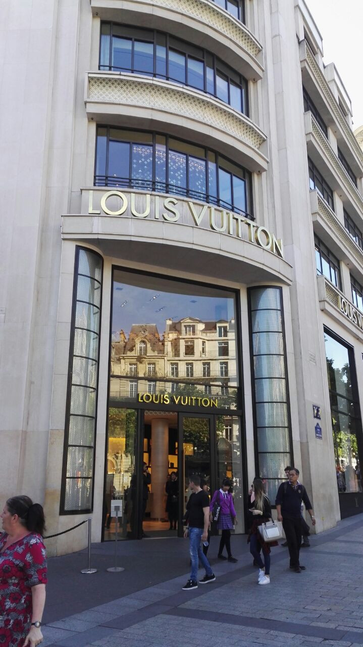 PARIS-APR 14: Customers are on queue to enter Louis Vuitton shop at Champ  Elysee avenue