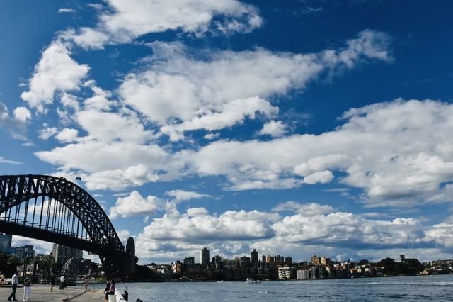 Sydney Opera House, Harbour Bridge, and clouds.