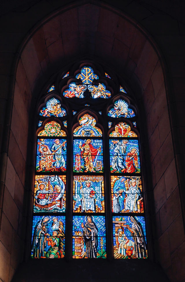 View St. Vitus Cathedral through the colorful stained glass windows.