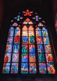 View St. Vitus Cathedral through the colorful stained glass windows.
