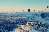 Hot air balloons flying all over the sky.