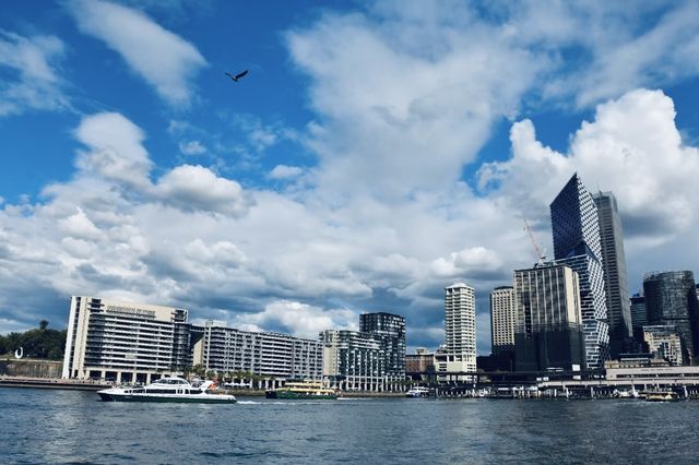 Sydney Opera House, Harbour Bridge, and clouds.