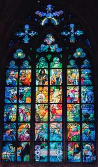 View St. Vitus Cathedral through the colorful stained glass windows.