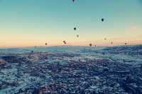 Hot air balloons flying all over the sky.