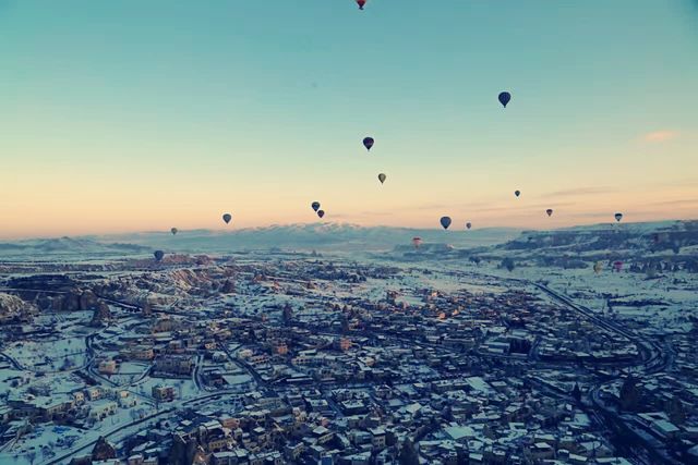 Hot air balloons flying all over the sky.