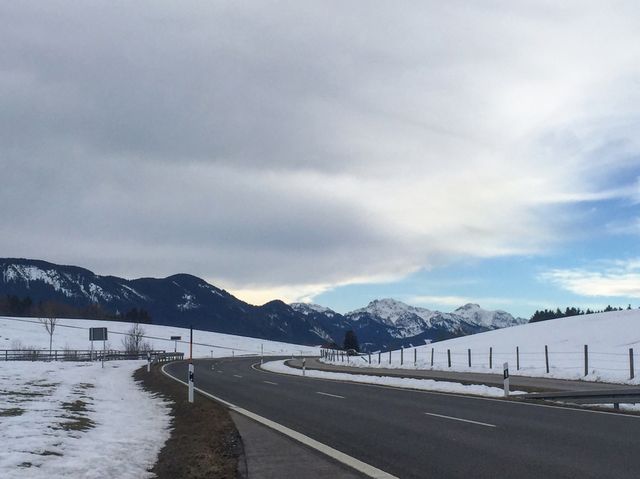 Wilderness church and snowy road scenery in the Bavarian Alps.