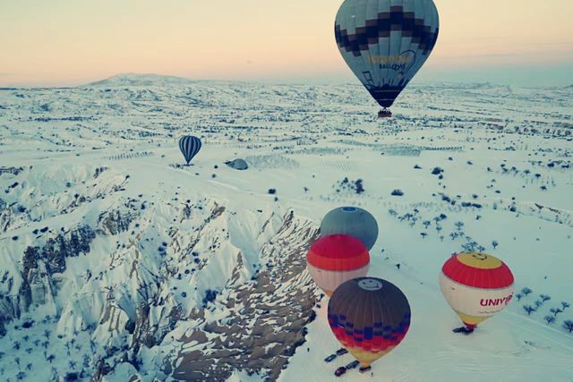 Hot air balloons flying all over the sky.