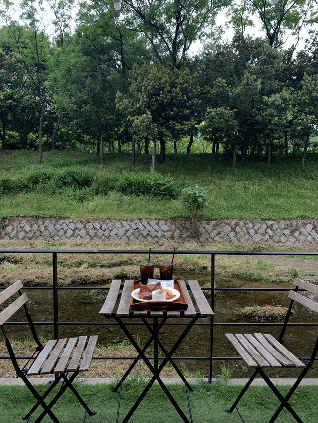 베란다카페 테이블 세팅과 개천 뷰 전경