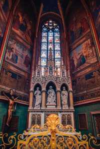 View St. Vitus Cathedral through the colorful stained glass windows.