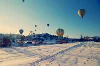 Hot air balloons flying all over the sky.