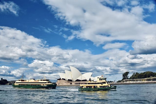 Sydney Opera House, Harbour Bridge, and clouds.