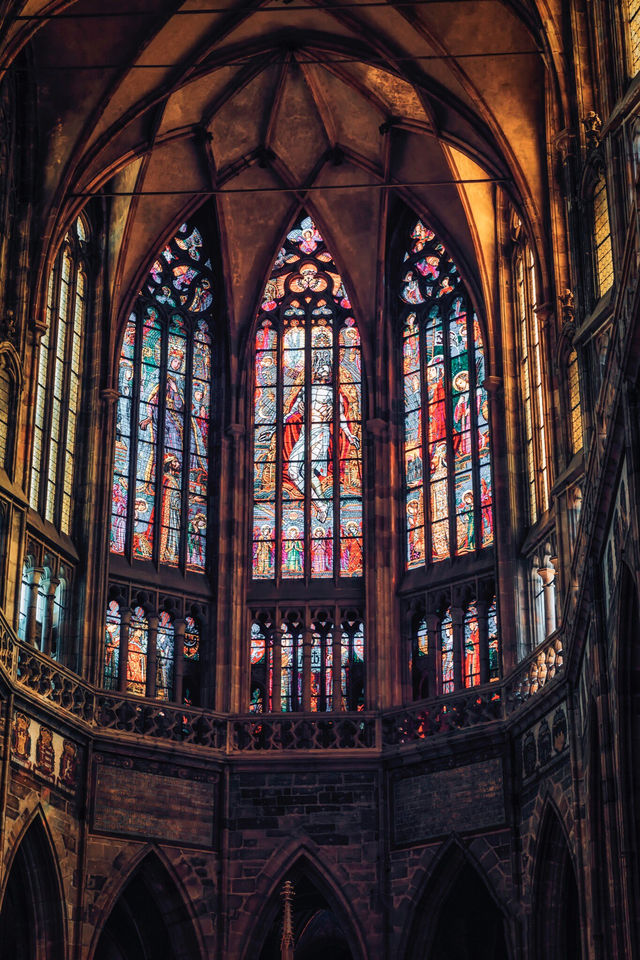 View St. Vitus Cathedral through the colorful stained glass windows.