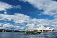 Sydney Opera House, Harbour Bridge, and clouds.