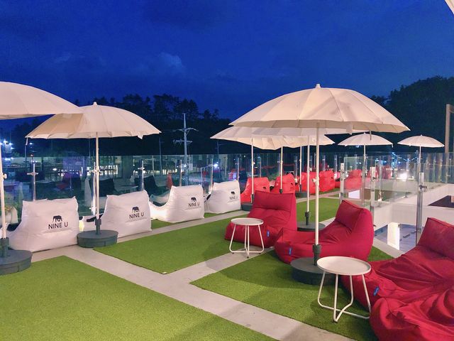나인유 루프탑 빈백 좌석과 파라솔 — 야간 감성