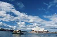 Sydney Opera House, Harbour Bridge, and clouds.