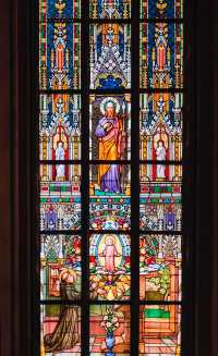 View St. Vitus Cathedral through the colorful stained glass windows.