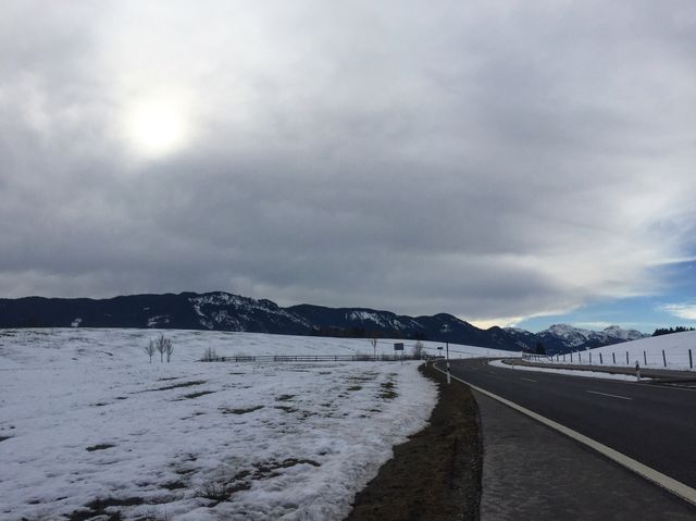 Wilderness church and snowy road scenery in the Bavarian Alps.