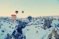 Hot air balloons flying all over the sky.
