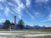 Wilderness church and snowy road scenery in the Bavarian Alps.