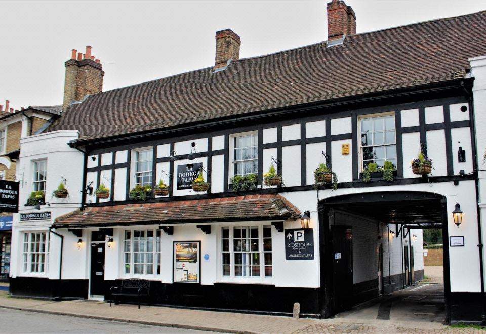 "a traditional black and white building with a sign that says "" hotel "" is shown on a street corner" at Rioshouse George-Inn
