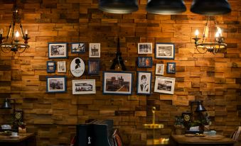 a wooden wall with numerous picture frames hanging on it , creating a unique and artistic display at Z Hotel