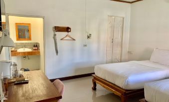 a hotel room with a white bed , wooden desk , and a coat hanger on the wall at Funwan Hotel