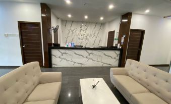 a modern reception area with two couches , a coffee table , and a marble wall , creating an inviting atmosphere at Havona Hotel - Kulai