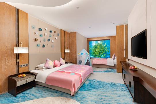 Ocean-themed family room at Dali Ocean Hotel with a built-in aquarium wall