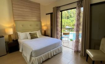 a large bed with white linens is in a room with a sliding glass door leading to a balcony at Sierra Resort