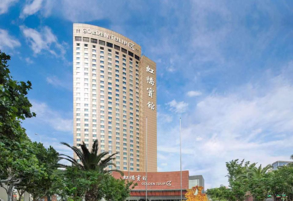 "There is a large building with the word ""hotel"" on its side, and in front of it, there is an office tower" at Golden Tulip Shanghai