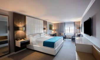 a modern hotel room with a large bed , white furniture , and a blue accent pillow at Westminster Hotel