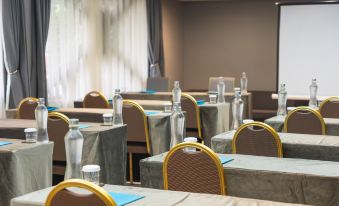 a conference room with several rows of chairs arranged in a semicircle , and bottles of water placed on the tables at Golden Star City Resort