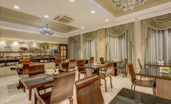 a dining room with wooden chairs and tables , along with a chandelier hanging from the ceiling at Hotel Lulu