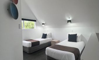 a hotel room with two beds , one on the left and one on the right side of the room at Asure Green Gables Motel