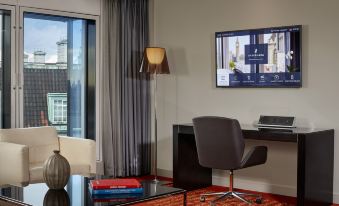a modern office space with a desk , chair , and a flat - screen tv mounted on the wall at Park Plaza Westminster Bridge London