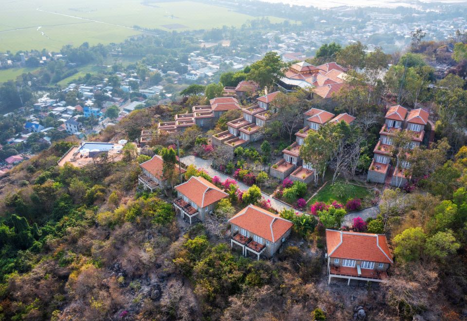 an aerial view of a residential area with several buildings , trees , and houses on a hillside at Victoria Nui Sam Lodge