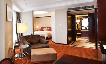 The living area of the room contains a bed, couch, and table, adjacent to a separate bedroom at Central Hotel Shanghai