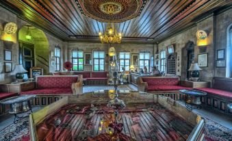 a large , ornate room with a chandelier hanging from the ceiling and multiple couches arranged around the room at Museum Hotel - Special Class