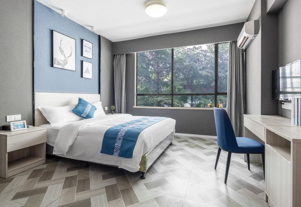 On the top floor, there is a bedroom with large windows, a bed, and a chair in the middle at Yimi Hotel (Guangzhou Sanyuanli Subway Station Jinlong Tengfei Fashion City Branch)