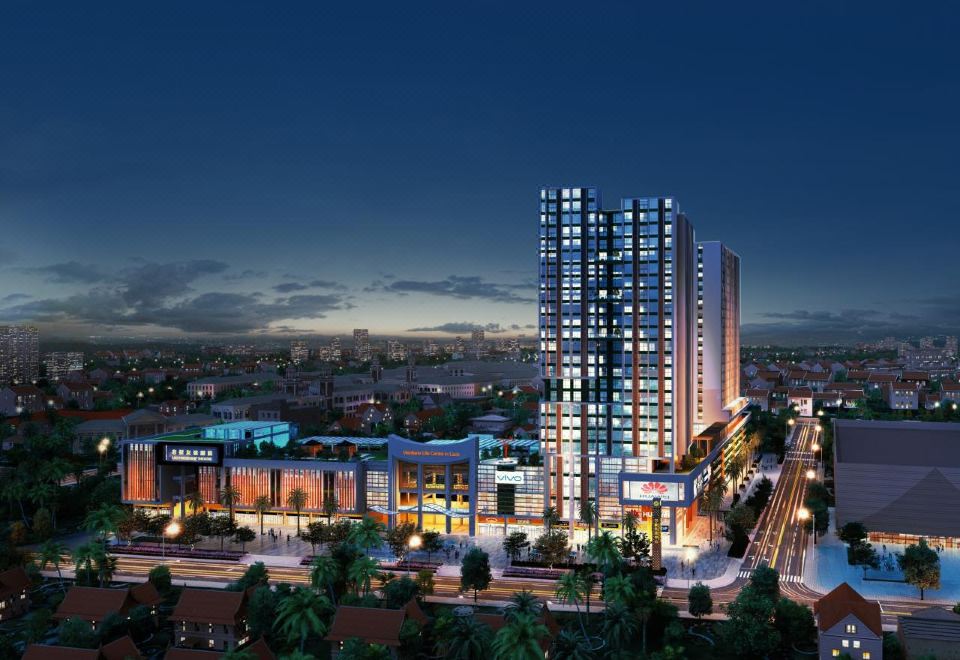 A well-lit city at night with a prominent building in the foreground and surrounding buildings at Landmark Vientiane Life Center