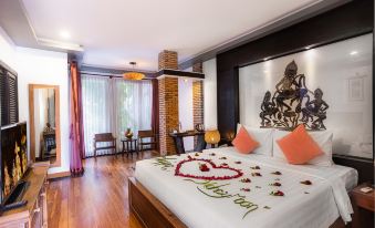 The middle room features a large bed and an open concept that connects to the living area and dining space at Sakaban Suite