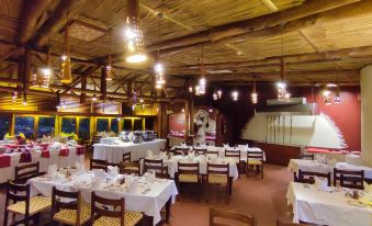 a large dining room with multiple tables and chairs , some of which are occupied by people at Amboseli Serena Safari Lodge