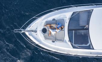 aerial view of a man and a woman in a white sailboat on the water at Naladhu Private Island Maldives