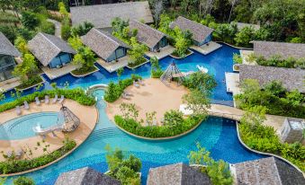 a resort with a large pool surrounded by multiple bungalows , providing a unique and relaxing atmosphere at Island Escape Burasari
