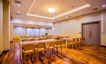 a large conference room with wooden tables and chairs , a projector screen , and a podium at Kacha Resort & Spa, Koh Chang