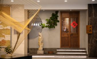 The room is decorated in red and has an entrance with wooden doors along one wall at Shanghai Shaanxi Business Hotel