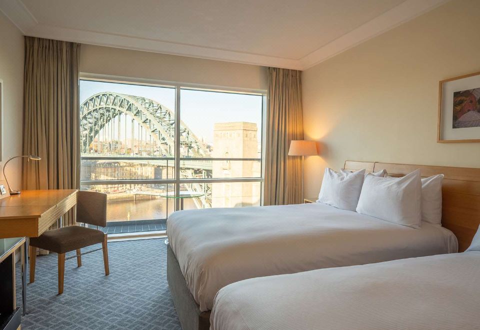 a hotel room with two beds , one on the left and one on the right side of the room at Hilton Newcastle Gateshead