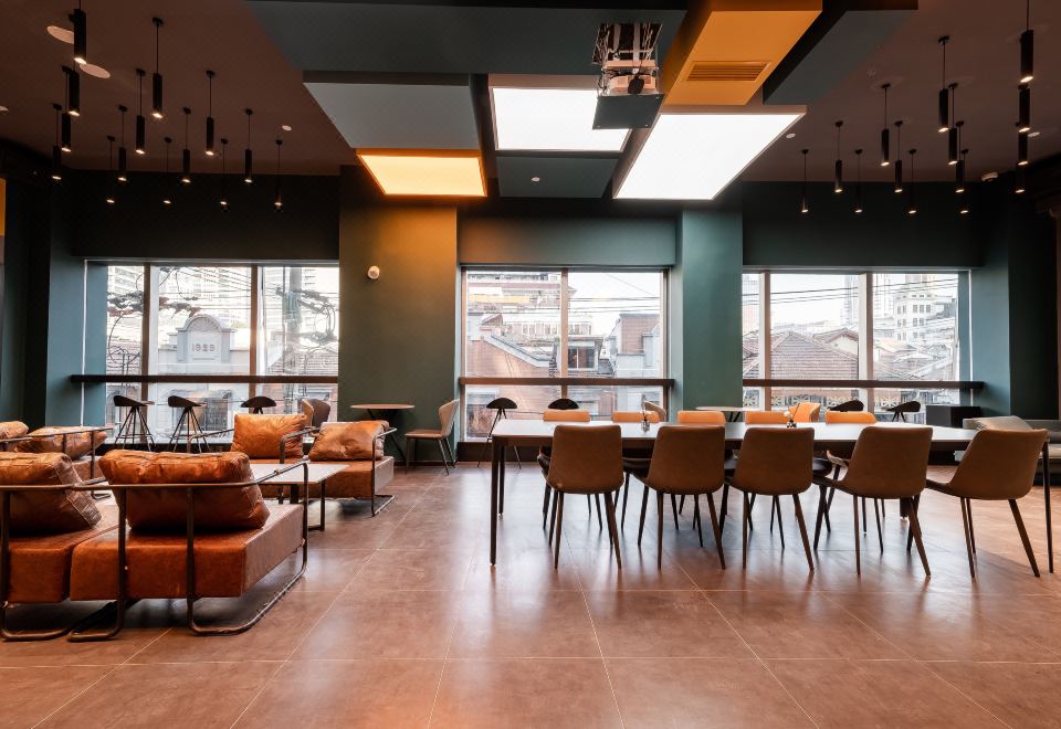 The restaurant features spacious tables and large windows, with an adjacent empty seating area at Dayin International Youth Hostel（East Nanjing Road & The Bund）